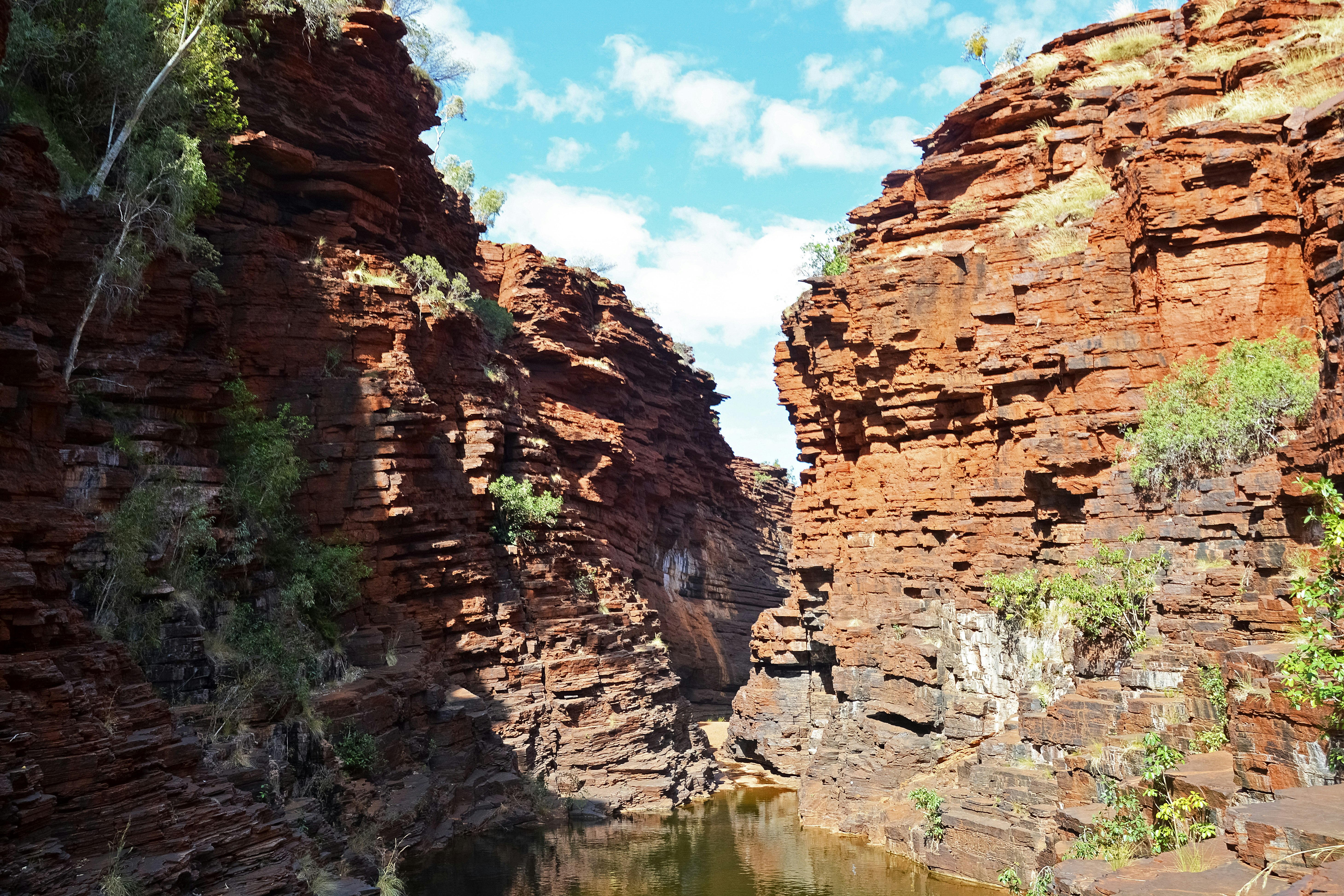 brown rocky mountain beside river during daytime